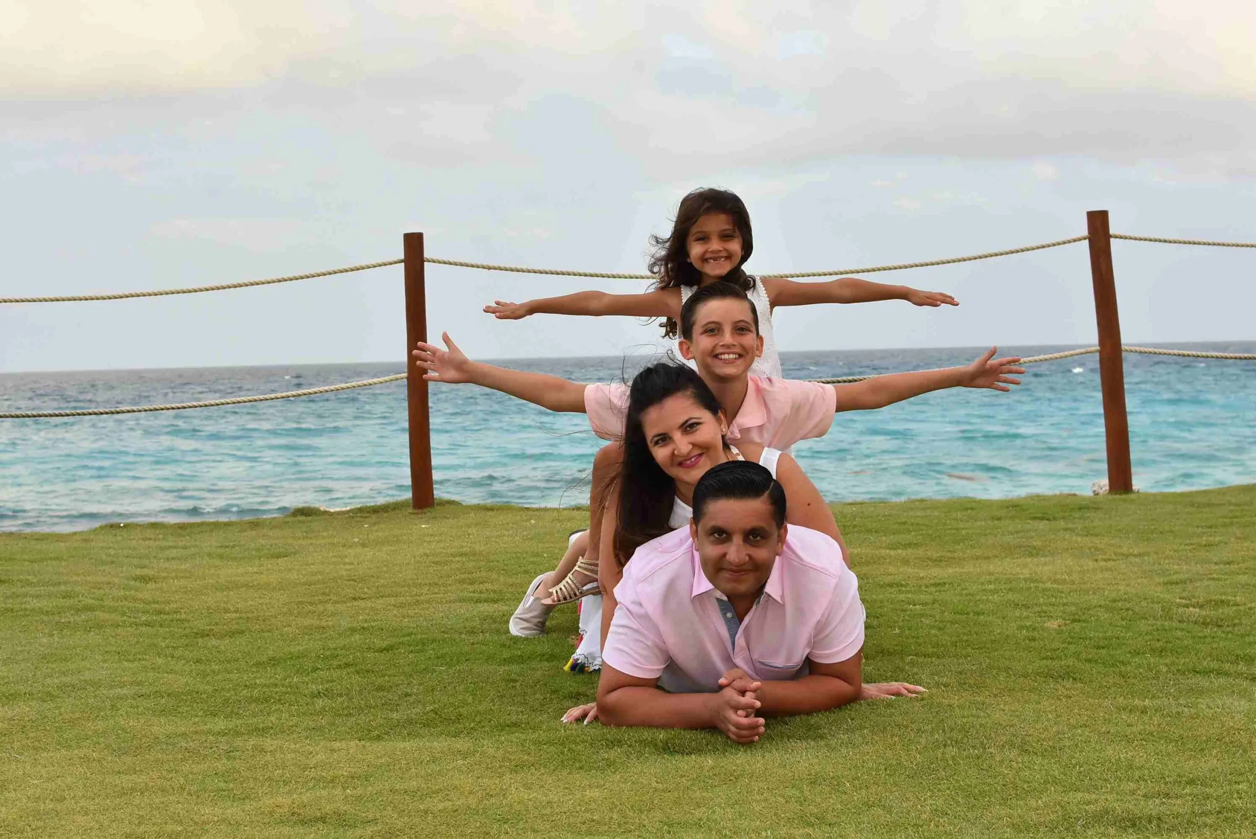 A family is posing for the camera on the grass.